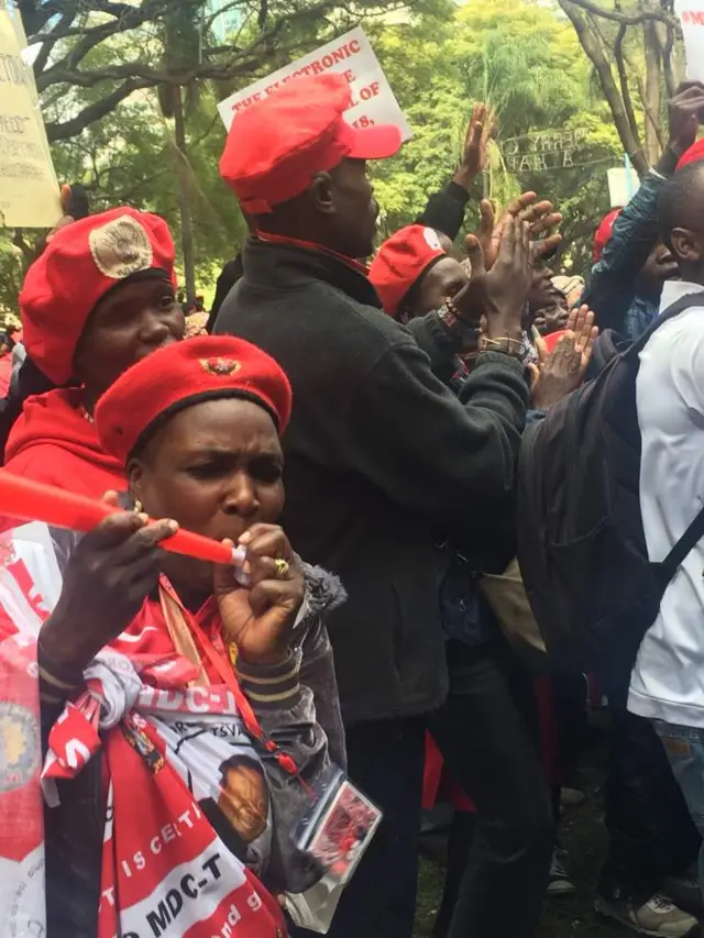 Supporters of Zimbabwe's opposition MDC party demonstrate with banners and vuvuzelas