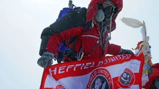 Ian Toothill with Sheffield United flag at the top of Everest