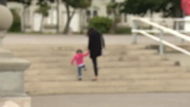 Woman holding a child's hand