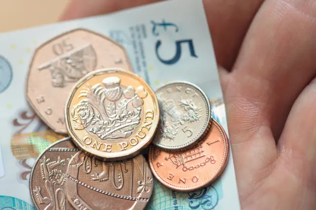 A person holding sterling cash