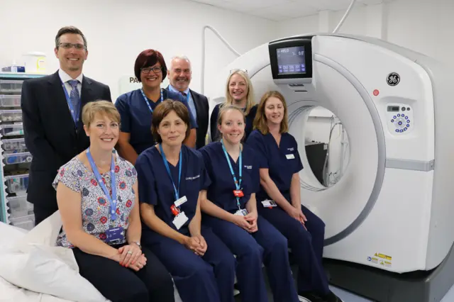 Hospital staff sitting next CT scanner