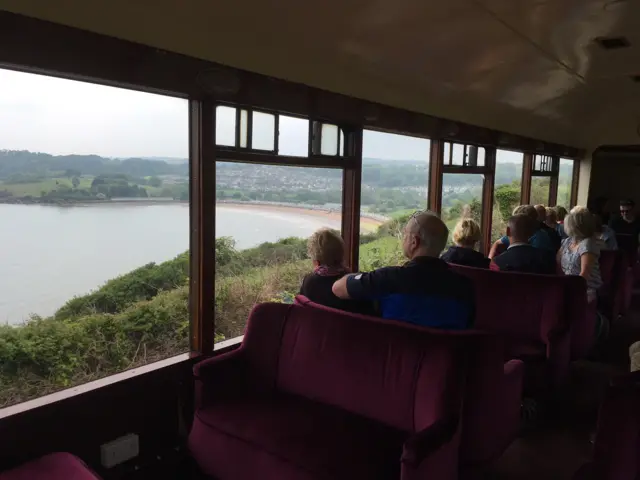 view from inside a train looking out over a beach