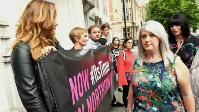 Human rights campaigners held banners at the Supreme Court in London on Thursday morning