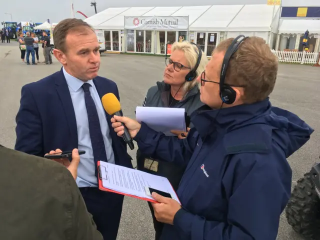 man being interviewed by two reporters