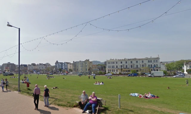 green space with hotels and houses behind