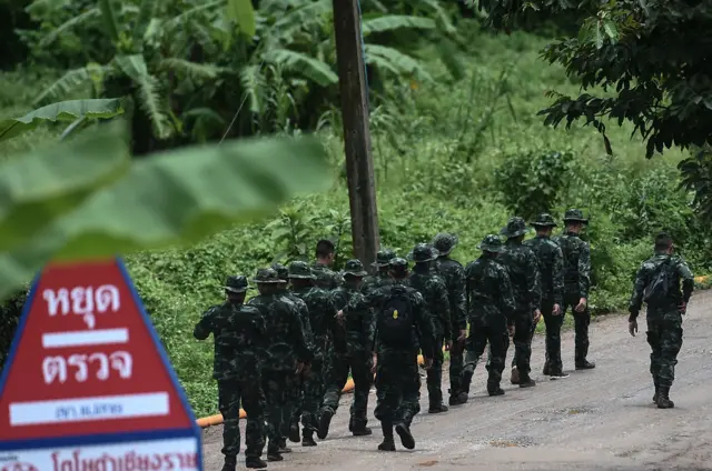 Thai soldiers walk into to the Tham Luang cave area