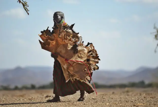 A Turkana woman in Kenya carrying goat skins