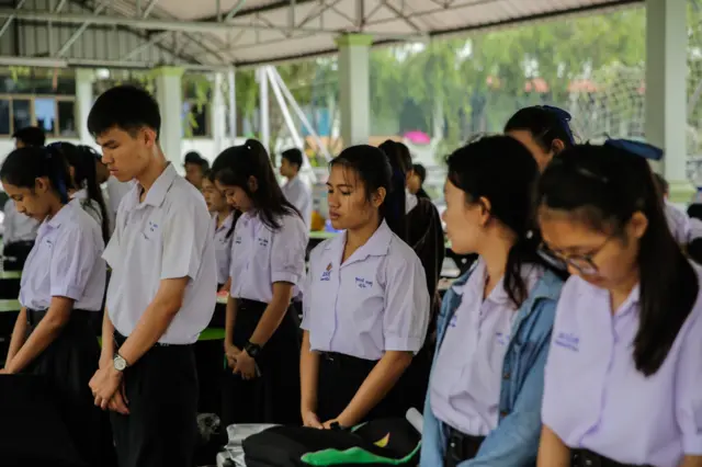 Classmates of the Wild Boars soccer team pray at the Maisai Prasitsart school