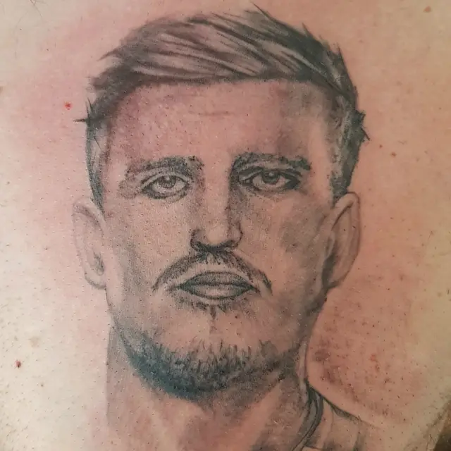 Tattoo of face on chest