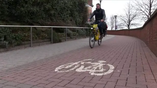 Man riding a bike down a hill in Sheffield city centre