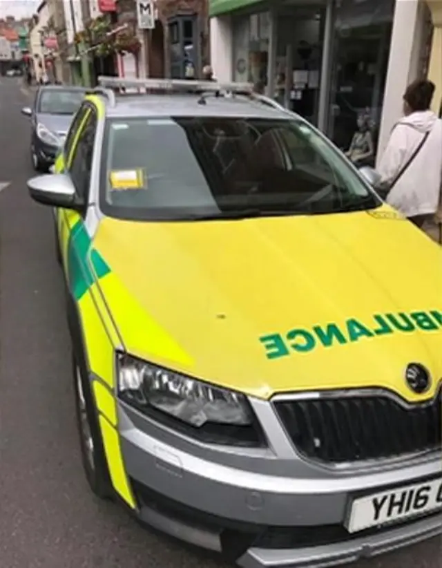 An ambulance with a parking ticket on it.