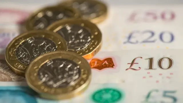 Pound coins on top of banknotes