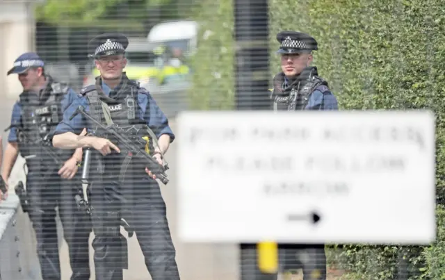 Security guards behind wire fence