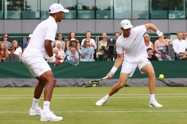 Raven Klaasen of South Africa and Michael Venus of New Zealand returns against Alex Bolt of Australia and Lleyton Hewitt of Australia