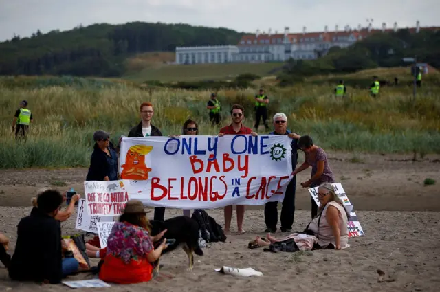 Protesters with their placards on the beach at Turnberry