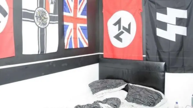 A bedroom with flags including Nazi symbols