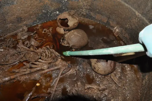 A handout picture released on July 19, 2018 by the Egyptian Antiques ministry shows skeletons in the black granite sarcophagus uncovered early this month in the Sidi Gaber district of Alexandria, filled with sewage water