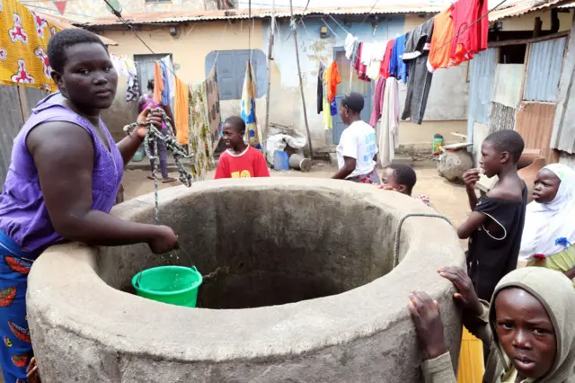 A woman draws water from a well. Lome, Togo.