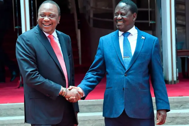 Kenya's President Uhuru Kenyatta (L) shakes hands with the National Super Alliance (NASA) coalition opposition leader Raila Odinga after a news conference at the March 9, 2018 at Harambee house office in Nairobi.