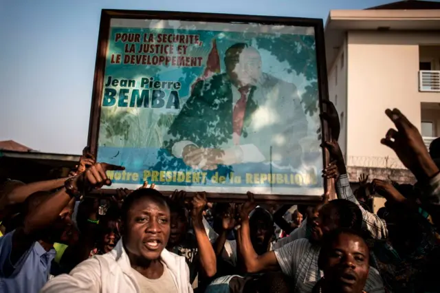 Supporters of Jean-Pierre Bemba hold his posteras they march to celebrate in Kinshasa on June 8, 2018