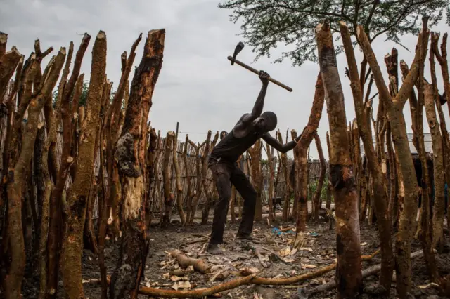 A picture taken on July 3, 2018, shows a man building his home after a World Food Programme (WFP) plane dropped sacks of maize and sorghum from air in Jeich village in Ayod County, northern South Sudan