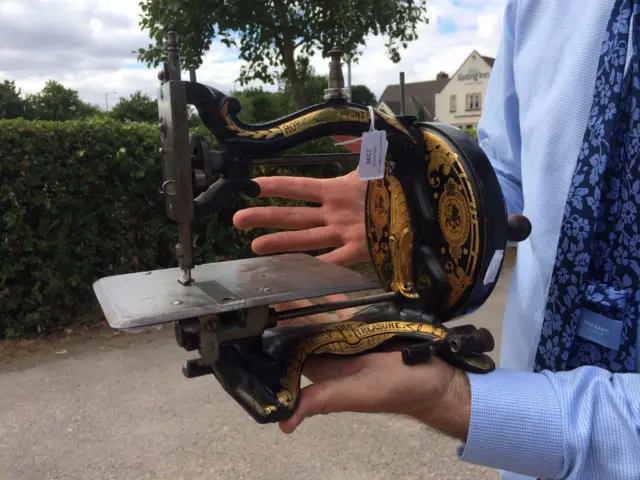 Charles Hanson holds the sewing machine