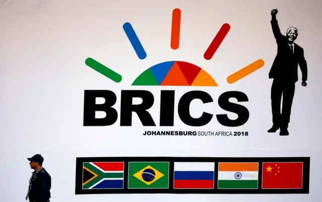 A police officer walks past a billboard outside the BRICS summit meeting in Johannesburg, South Africa, July 25, 2018.