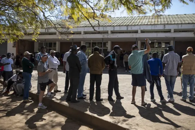 Members of the public queue at a polling station to cast their vote in the Zimbabwean General Election in the Borrowdale area on July 30, 2018 in Harare