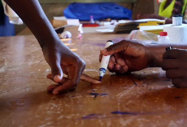 A voter has a finger marked before casting a vote at the Batsirai Primary school just outside Harare, Zimbabwe, 30 July 2018