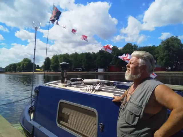 Captain Grunt (Grant Williams) aboard his  narrow boat Nellie 2 on the River Trent.