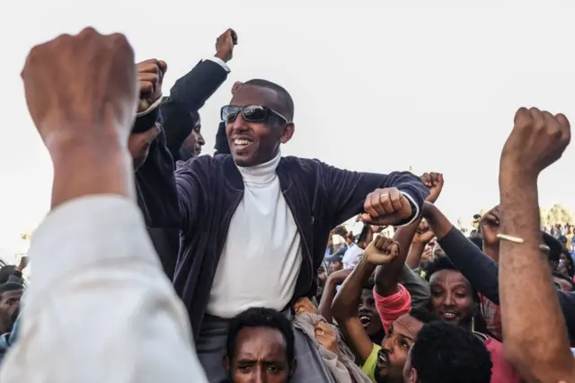 Ehiopian politician Andualem Arage (C) , who was given a life prison sentence in 2012 on accusations of links to the banned Ginbot 7 group, reacts with people after being released from Kaliti Prison in Addis Ababa on 14 February 2018