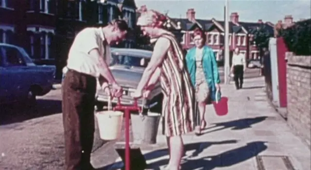 People getting water from pipes in the street