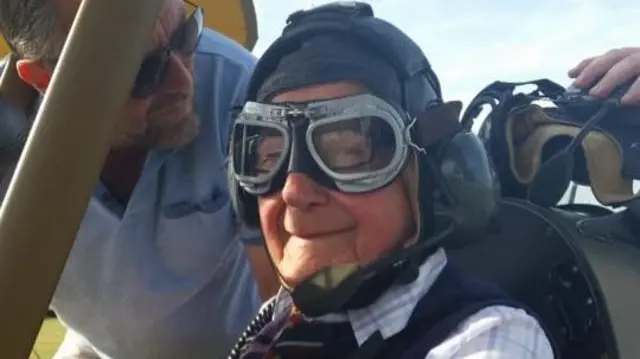 Man in cockpit wearing a hat and goggles