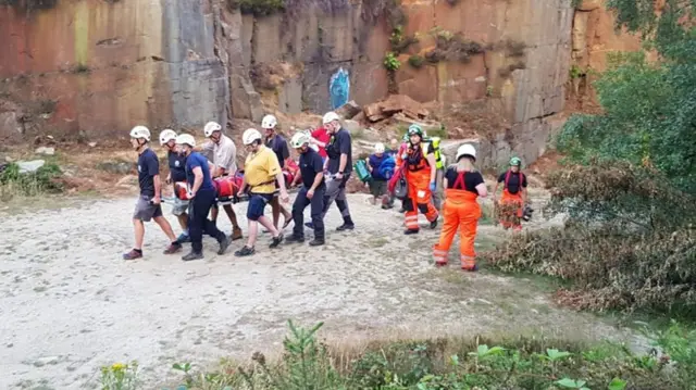 Climber carried away on a stretcher by mountain rescue teams