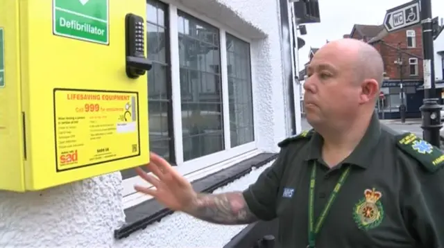 Ambulance crew approaches wall mounted