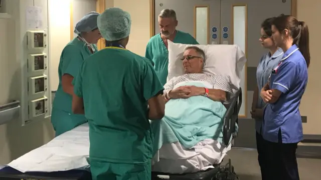 Eric on hospital bed with doctors