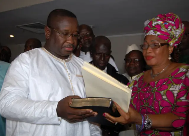 Julius Maada Bio (L) prepares to take the oath of office as new president of Sierra Leone on April 4, 2018