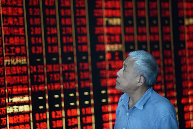 A man looks at a stock market board in China