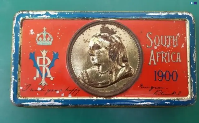 The tin of chocolate showing Queen Victoria on it and the words south Africa 1900.