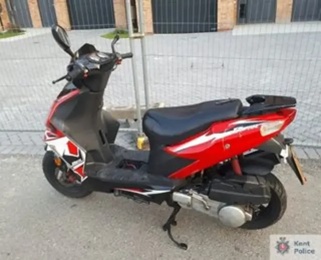 A red and black moped