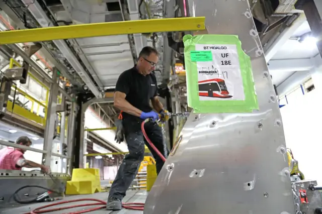 An employee works on a jnew tram at Bombardier's factory in Toronto