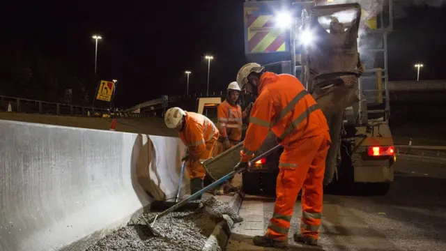 Workmen help building a concrete barrier on the M621 near Leeds.