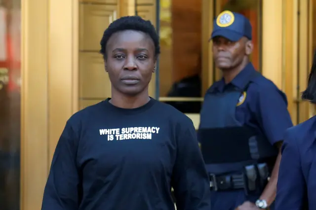 Patricia Okoumou walks out of federal court from her arraignment, a day after authorities say she scaled the stone pedestal of the Statue of Liberty to protest U.S. immigration policy