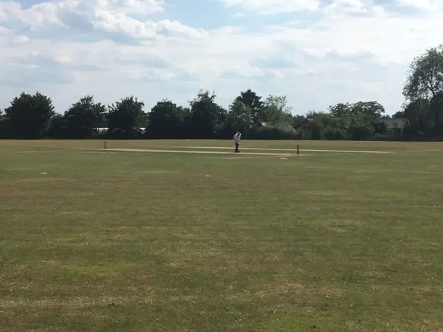 Umpire standing alone at a cricket match