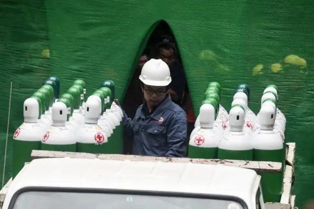 Rescue workers move air tanks to the area