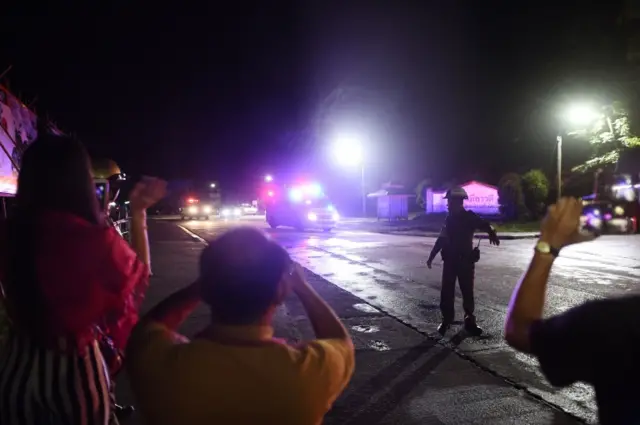 People take photos of ambulances arriving at Chiang Rai hospital