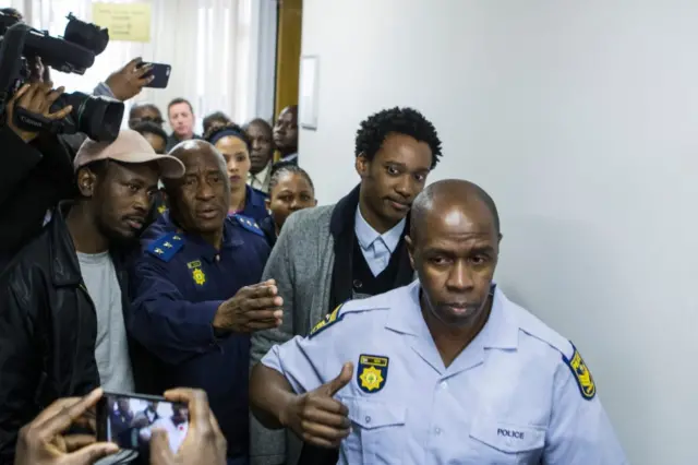 Duduzane Zuma (2R), son of former South African president Jacob Zuma, leaves the court, where he faced corruption charges before being released on bail on July 9, 2018 in Johannesburg