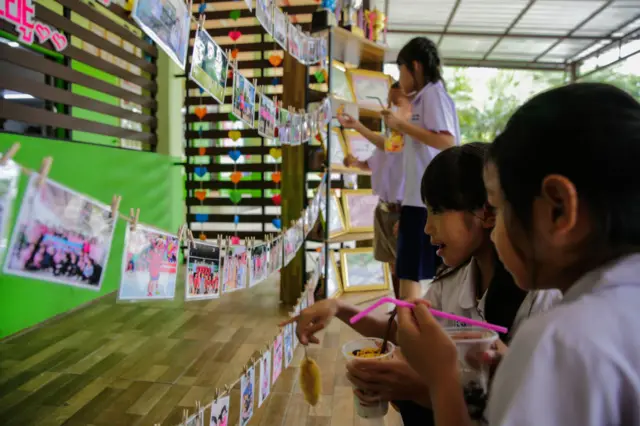 Classmates of Adul, one of the boys trapped in Tham Luang Nang Non cave, visit a tribute for the Wild Boars soccer team