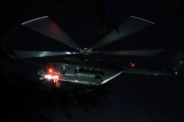 A military helicopter carrying rescued schoolboys approaches to land at a military airport in Chiang Rai