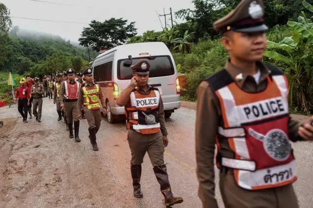 Thai policemen secure the road leading to Tham Luang cave area